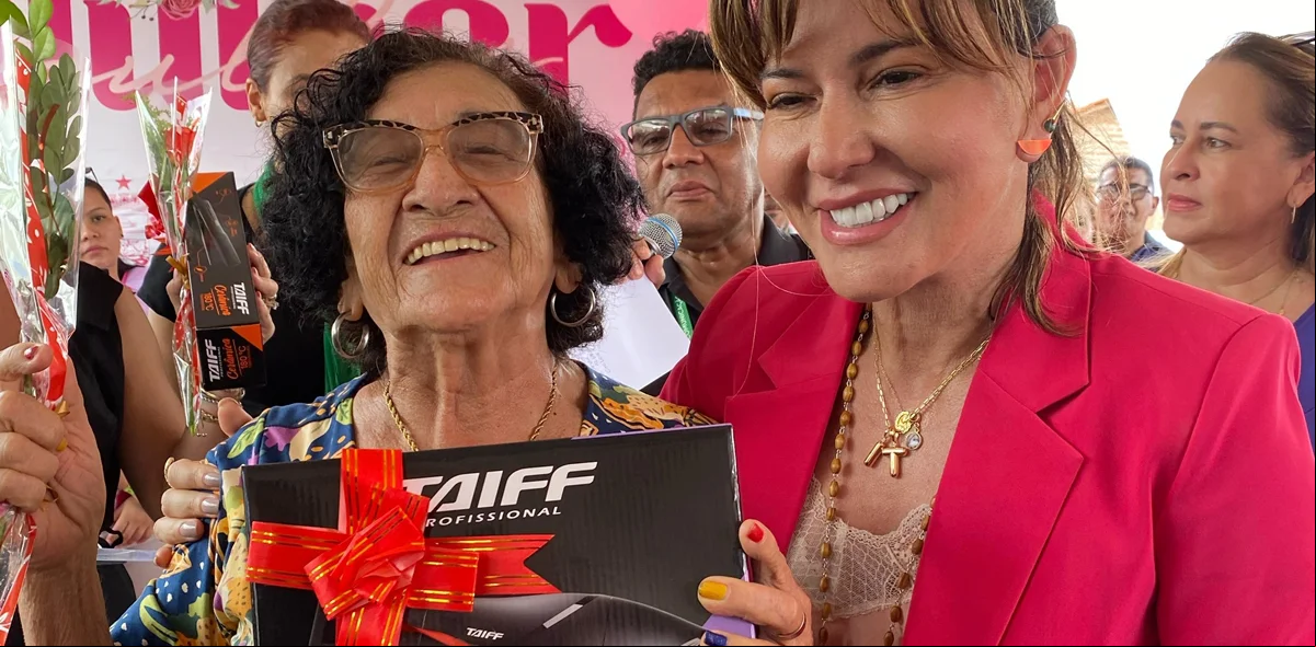 Mulher ganhando brinde da prefeita Ivanária