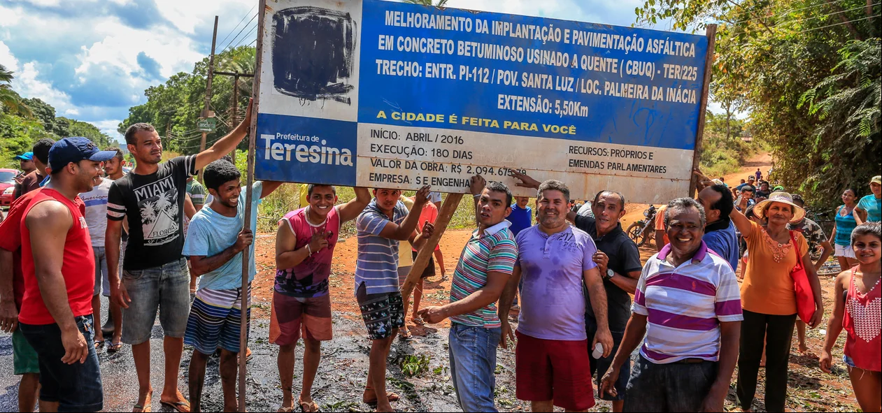 Moradores mostram a placa de melhorias no povoado 